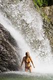 happy woman under waterfall