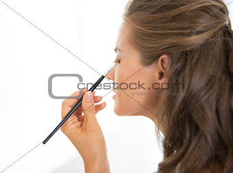 Young woman applying makeup