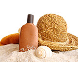 Straw hat with towel and suntan lotion on white