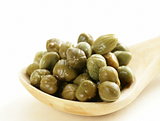 Pickled gourmet green capers in a wooden spoon