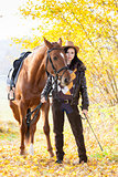 equestrian with her horse in autumnal nature