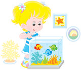 Girl looking at aquarium fishes
