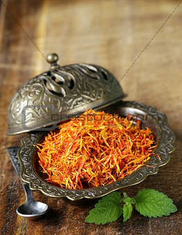 Saffron spice in metal bowl macro shot soft focus