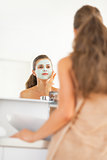 Young woman wearing facial cosmetic mask