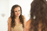 Portrait of young woman with wet hair looking in mirror