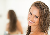 Portrait of smiling young woman with long wet hair in bathroom