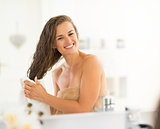 Happy young woman wiping hair with towel