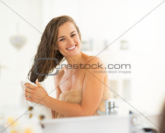 Happy young woman wiping hair with towel