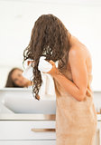Closeup on happy young woman wiping hair with towel