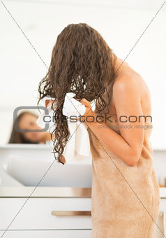 Closeup on happy young woman wiping hair with towel