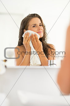 Portrait of young woman wiping with towel in bathroom
