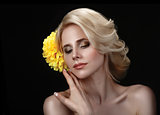 Beautiful young blond woman on a black background with a yellow 