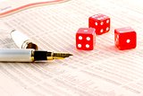 red dice and a golden pen  on the financial newspaper