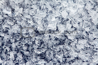 Ice crystals of frozen water on a dark surface