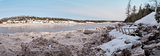 Panorama of forest river covered with snow and ice