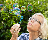 Senior woman blowing bubbles 