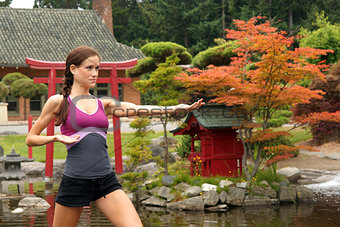 Fit Woman in Fighting Pose Near Yoga Pond Outside