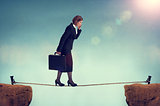 confident businesswoman walking a tightrope