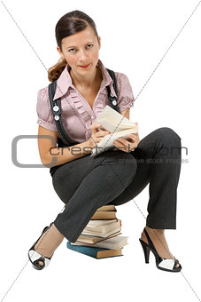 woman reading sitting on a pile of books