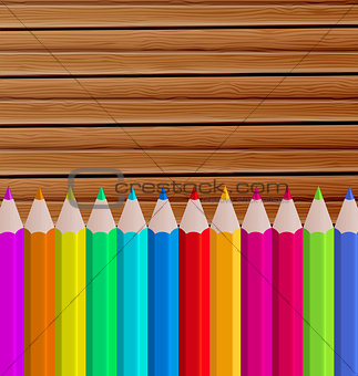 Palette pencils on wooden background