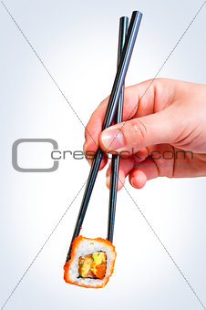 female hand holding chopsticks Japanese roll