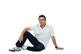 attractive healthy adult man sitting on floor with jeans isolated
