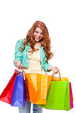 smiling young redhead girl with colorful shoppingbags 