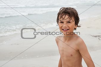 smiling little kid boy child on the beach in summer vacation