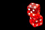 two red dice on black background