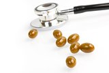 pills with unfocused stethoscope on background