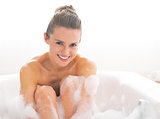 Portrait of happy young woman in bathtub