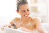 Portrait of happy young woman in bathtub