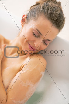 Portrait of relaxed young woman laying in bathtub
