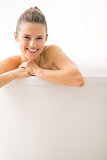 Portrait of smiling young woman in bathtub