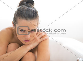 Frustrated young woman sitting in bathtub
