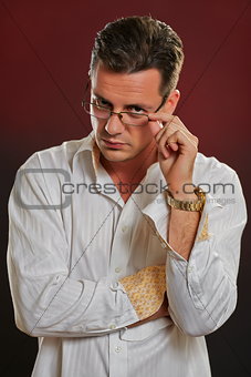 Suspicious man looking over eyeglasses