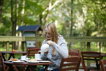 Young woman enjoying a pot of tea