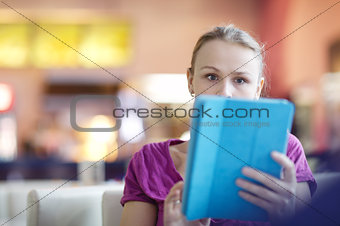 Woman in a terminal using her tablet