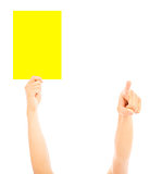 Hand of referee with big yellow card to warn