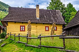View of traditional village house and wooded statues