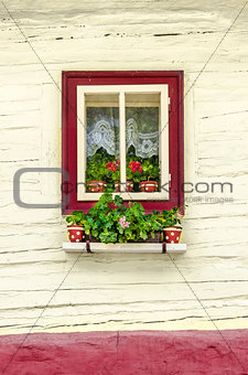 Detail of colorful window with flowers on old traditional house