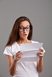 girl reading astonishing news on white letter