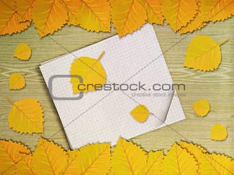 Yellow leaves over wooden background