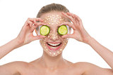 Happy young woman with making oatmeal mask with cucumber