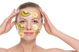 Young woman making fruit facial mask