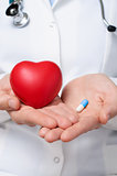 Doctor holding a heart and a pill