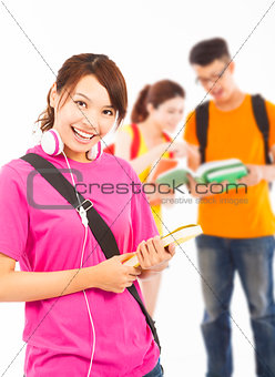 smiling young student holding books and earphone with classmates