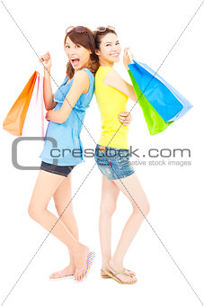 pretty young sisters standing and holding shopping bags