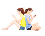 two happy pretty girls playing smart phone
