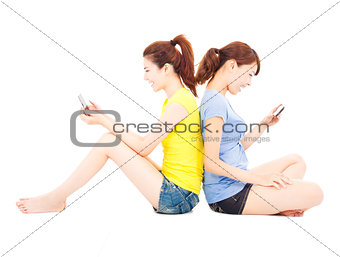 two happy young woman playing smart phone
